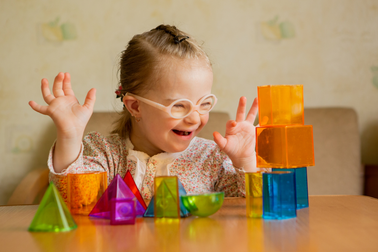 Joyful child with colorful learning blocks celebrating a breakthrough moment